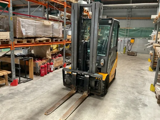 Jungheinrich electric forklift between racks, front view