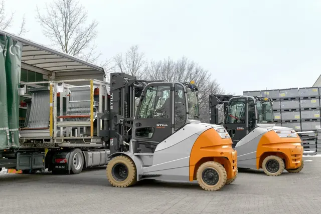 Two STILL electric forklifts beside a truck being loaded