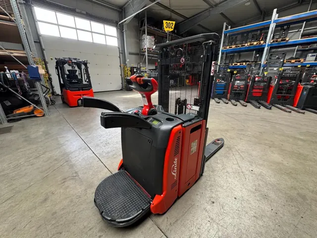 Red Linde electric pallet truck with an operator platform