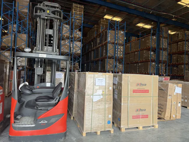 Reach truck operator compartment next to palletised boxes in a warehouse